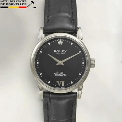 a close up of a black watch with roman numerals on the face