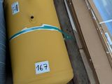 un grand réservoir jaune posé sur une palette, à côté d'autres cartons