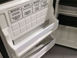 an open refrigerator with its door open on the floor