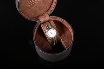 une montre dans un étui en cuir posée sur une surface noire