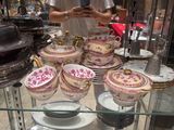 a man standing in front of a glass display case with plates and bowls