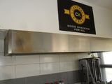 a sign on the wall above a stove in a kitchen