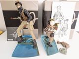 two figurines of a man and a woman on a surfboard