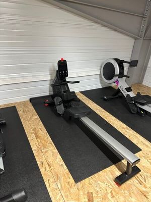 une salle de sport équipée d'une rangée d'appareils de musculation fixes