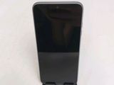 a close up of a black cell phone on a white surface