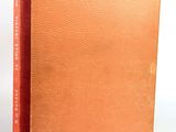 an orange book sitting on top of a table next to a white wall