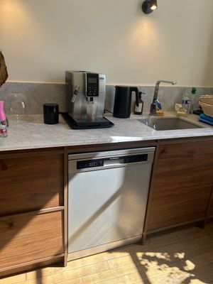 a kitchen with a sink, dishwasher, and a coffee maker
