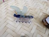 a blue and white hair comb sitting on top of a wooden floor
