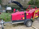 une voiture rouge garée à côté d'un barbecue