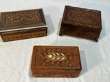 trois petites boîtes en bois posées sur une table blanche