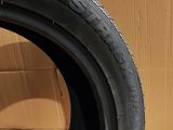 tire on the ground next to a cardboard box with a cardboard box in the background