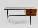 Le bureau est en bois et en métal, avec un plateau noir.