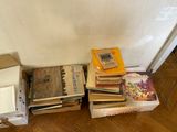 a pile of books sitting on the floor next to a wall