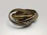 a close up of three rings on a white surface
