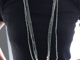 a woman that is wearing a black shirt and some necklaces