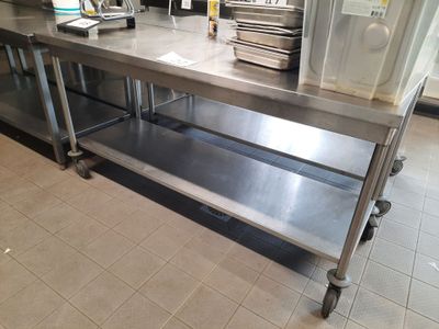 a large stainless steel table with a bunch of plates on it