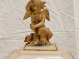 a clock with a statue of an angel on top of it