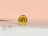 a gold coin sitting on top of a marble counter top