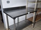 a stainless steel work table with a shelf on it