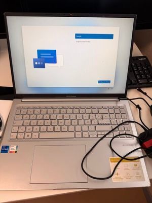 un ordinateur portable posé sur un bureau, avec une souris et un clavier