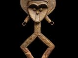 une image représentant une sculpture en bois d'un homme portant un casque sur la tête