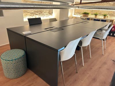 a long table with a laptop on it in the middle of a room
