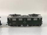 two toy trains sitting side by side on a white surface