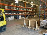 un chariot élévateur dans un entrepôt rempli de palettes et de cartons