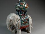 a statue of an elephant with a vase on top of it