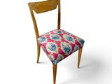 une chaise en bois dont l'assise est ornée d'un motif rose et bleu