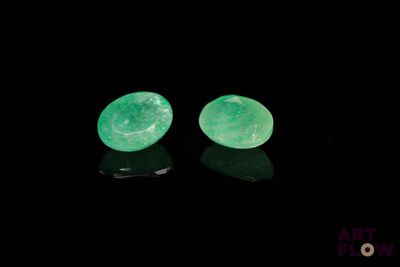 a pair of green jade earrings on a black surface