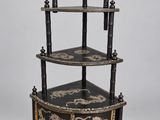 a black and gold decorated corner shelf with three shelves on each side