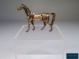 statue d'un cheval dans une boîte transparente posée sur une surface blanche
