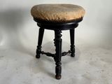 un tabouret noir surmonté d'un coussin beige