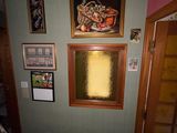 une photo d'une pièce avec un radiateur et des tableaux accrochés au mur