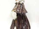 une figurine représentant une vieille femme tenant un sac