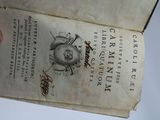 a hand holding an old book with a drawing on it