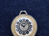 a close up of a pocket watch on a blue cloth