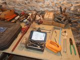 a table with tools on it in front of a stone wall