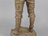 bronze statue of a man holding a baseball bat on a base