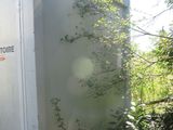 a white outhouse sitting in the middle of the woods