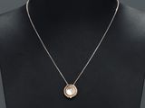 un collier en or avec un pendentif en perle autour du cou d'un mannequin