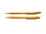 two pens sitting next to each other on a white surface