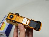 a person holding a yellow toy truck in their hand