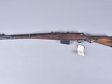 the rifle is laying on the table next to the tag