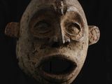 un gros plan d'un masque en bois sur fond noir