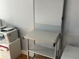un bureau sur lequel se trouve une imprimante, dans une petite pièce