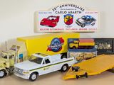 a toy truck with a flatbed trailer and other toy vehicles on a table