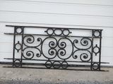 a black iron bed frame sitting outside of a garage