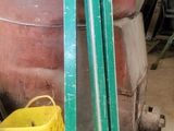a large metal container with a green handle next to buckets of paint